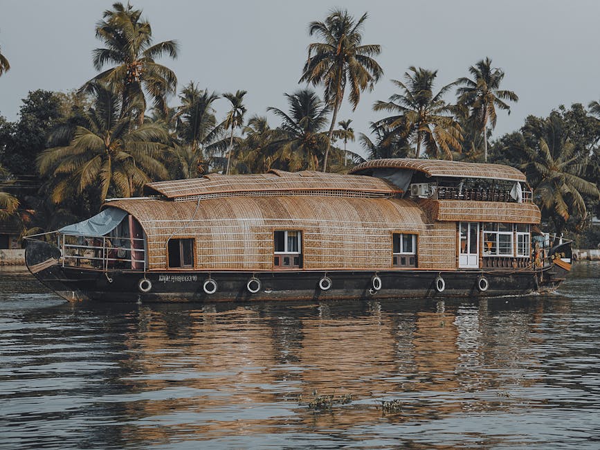 Traditional houseboat cruising in a tropical waterway surrounded by lush palm trees.